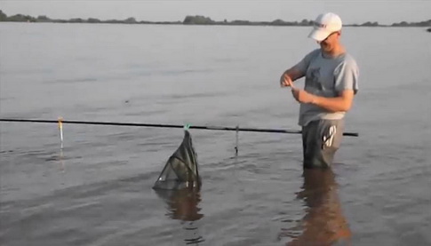 Рыболов с удочкой в воде